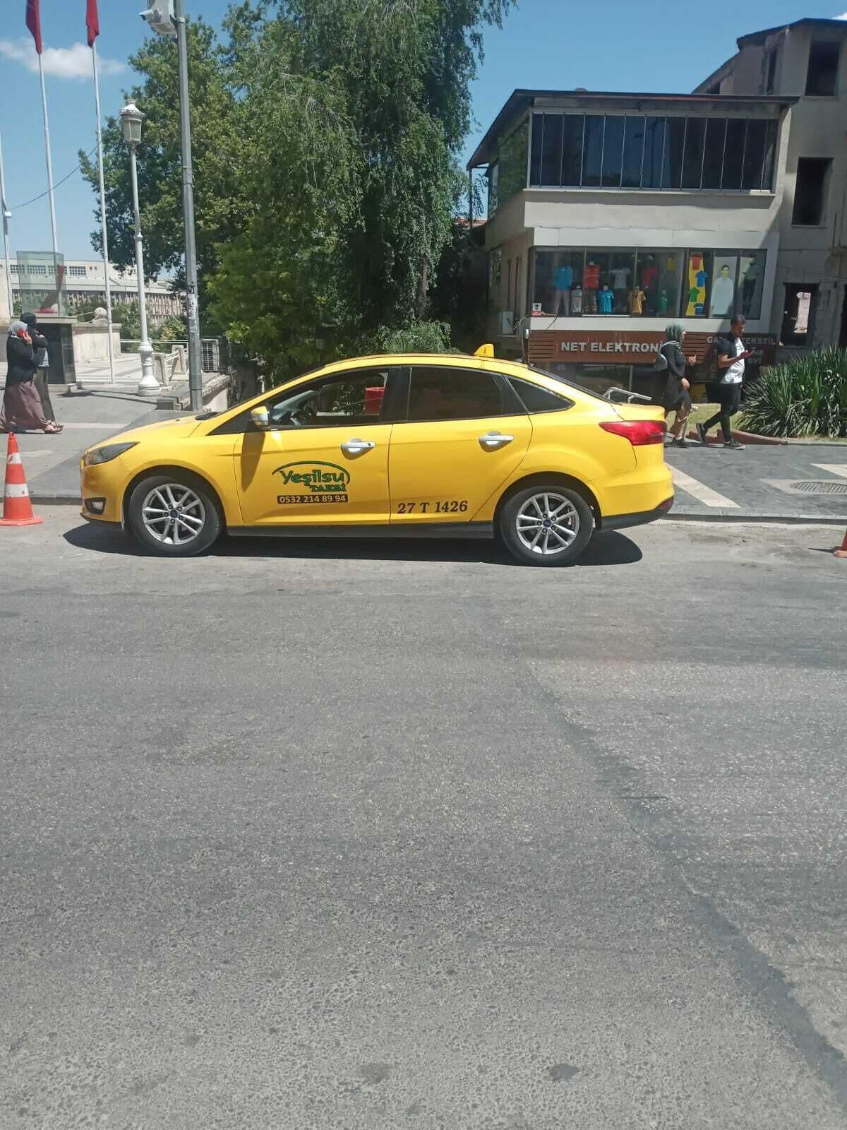 A yellow taxi parked on a street.