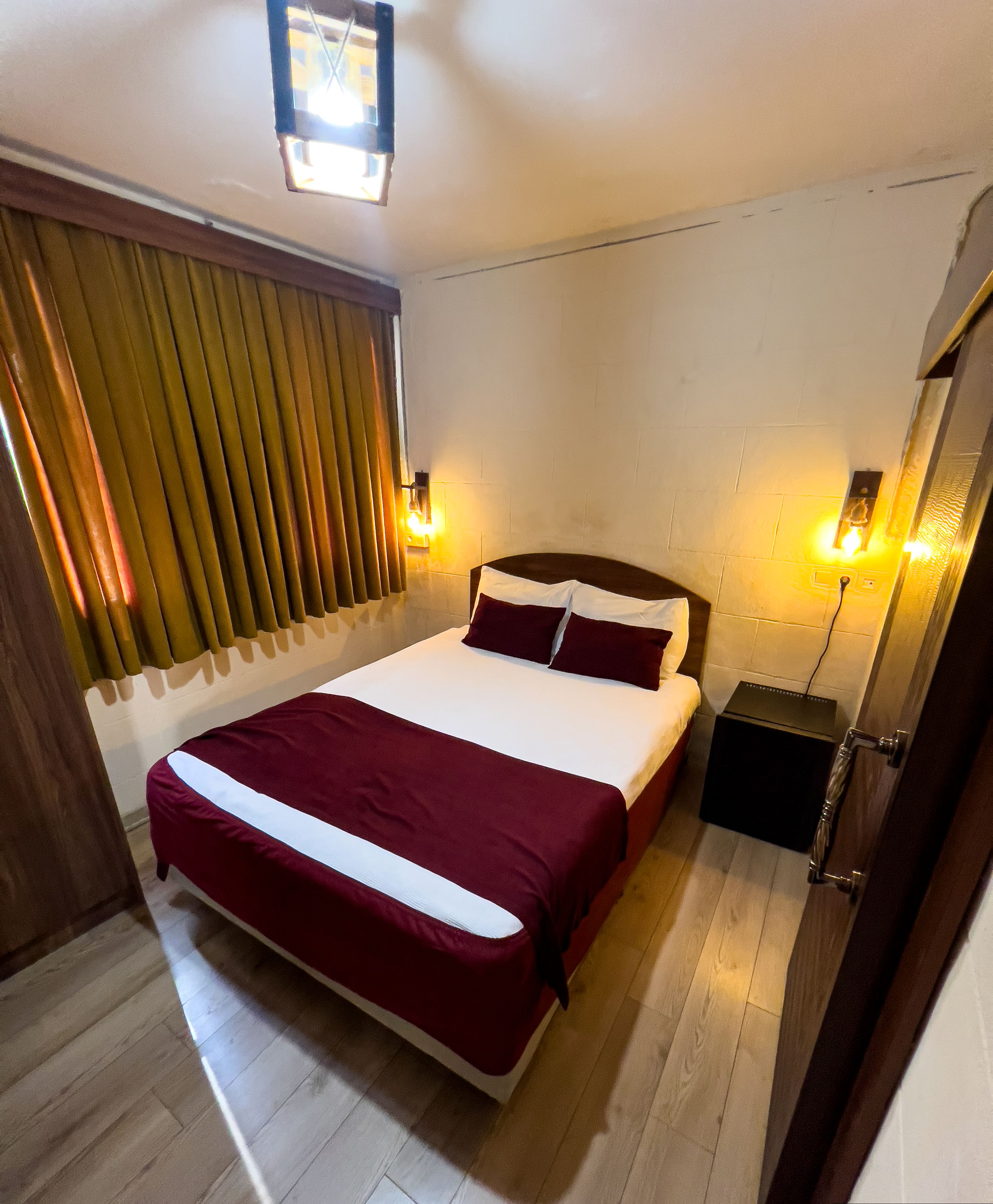 Une chambre d’hôtel avec un grand lit, un plancher en bois et deux lampes de chevet.