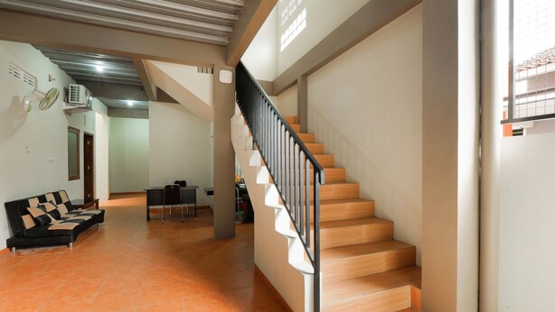 Un vaste espace de vie comprenant un escalier, un canapé et une table à manger.