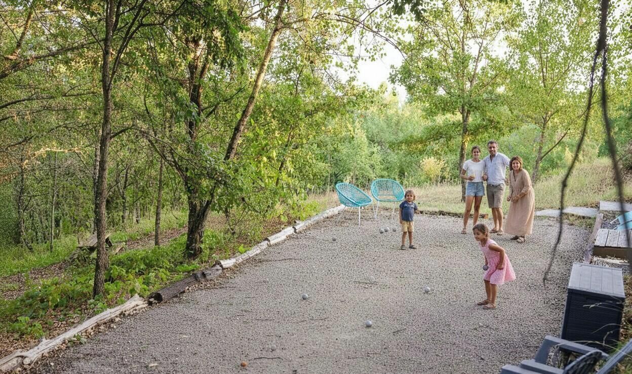 A family in a park with a gravel path, trees, and blue chairs.