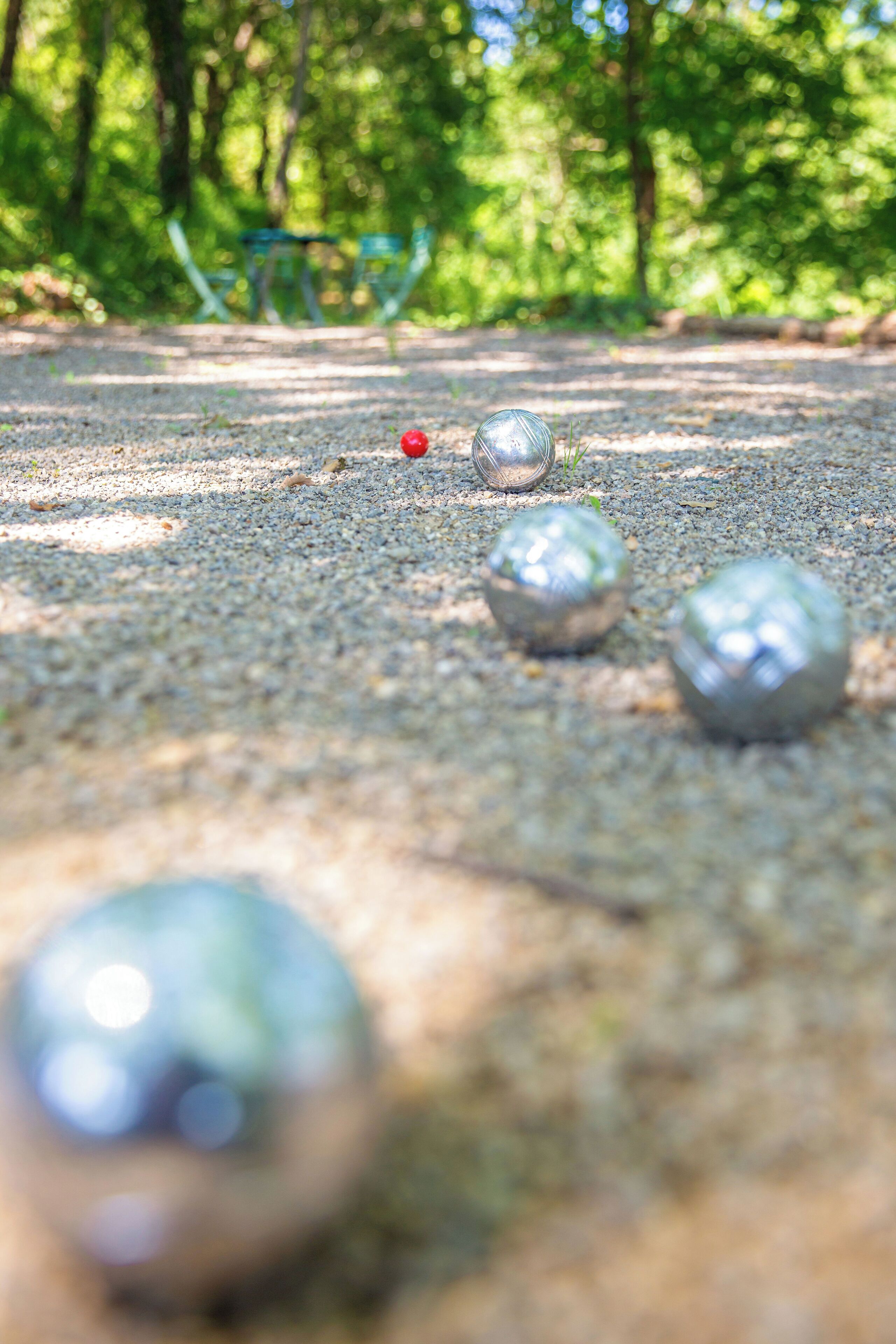 A close-up of a golf course with a focus on the ground and a few golf balls.