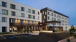 A Courtyard by Marriott hotel with a modern design, featuring a covered entrance and a parking lot with handicapped spaces. - Courtyard BY Marriott Pocatello (Pocatello)