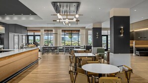 A modern dining area with a long counter, multiple tables, and chairs. - Courtyard BY Marriott Pocatello (Pocatello)