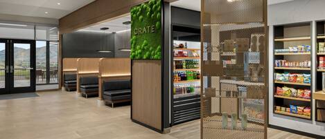 A modern interior with seating areas, a refrigerated section, and a view of the outdoors.