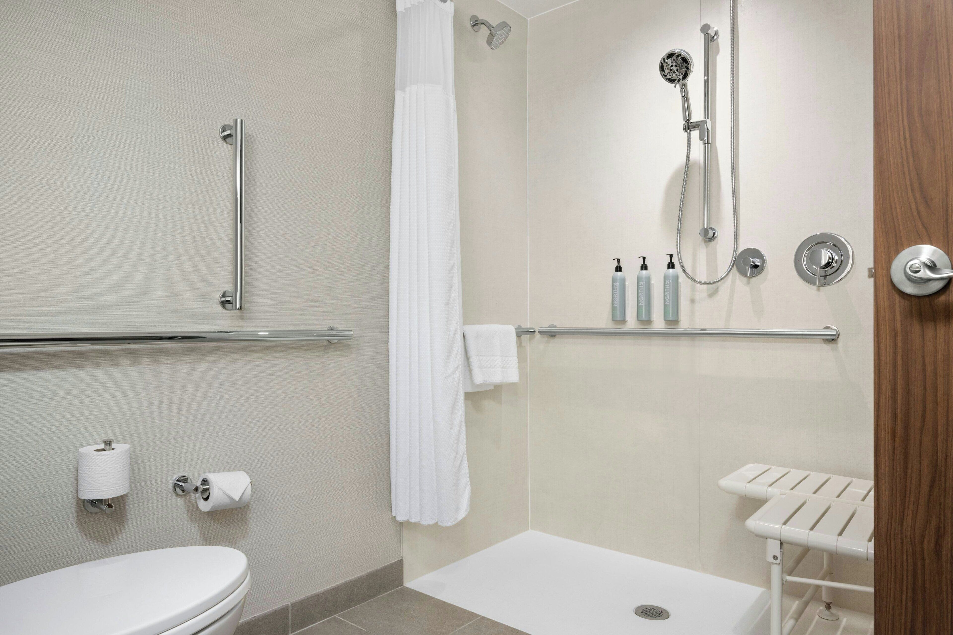 A modern bathroom with a toilet, a shower, and a bathtub.