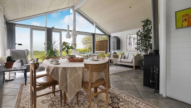 A spacious dining area with a round table, chairs, and a view of the outdoors. - Stunning home in Vestervig with sauna (Vestervig)