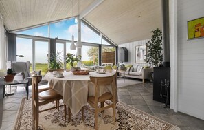 A spacious dining area with a round table, chairs, and a view of the outdoors. - Stunning home in Vestervig with sauna (Vestervig)