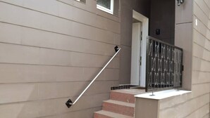 Un escalier avec une rampe, une porte et une fenêtre.