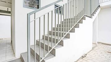 Uma escadaria com guarda-corpos de metal que dá acesso a um andar superior.