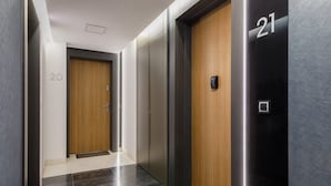 A modern hallway with two elevators, one marked with the number 20 and the other with 21. - Comfortable Apartment | Balcony | Parking | Close to Park (Swinoujscie)