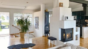 Una sala de estar moderna con chimenea, piso de madera y un sofá.