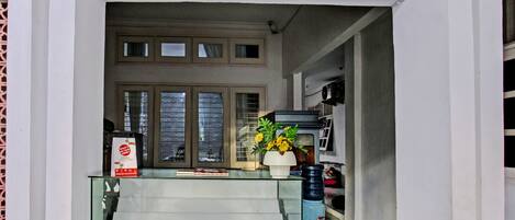 A modern interior with a glass staircase leading to a second-floor balcony.