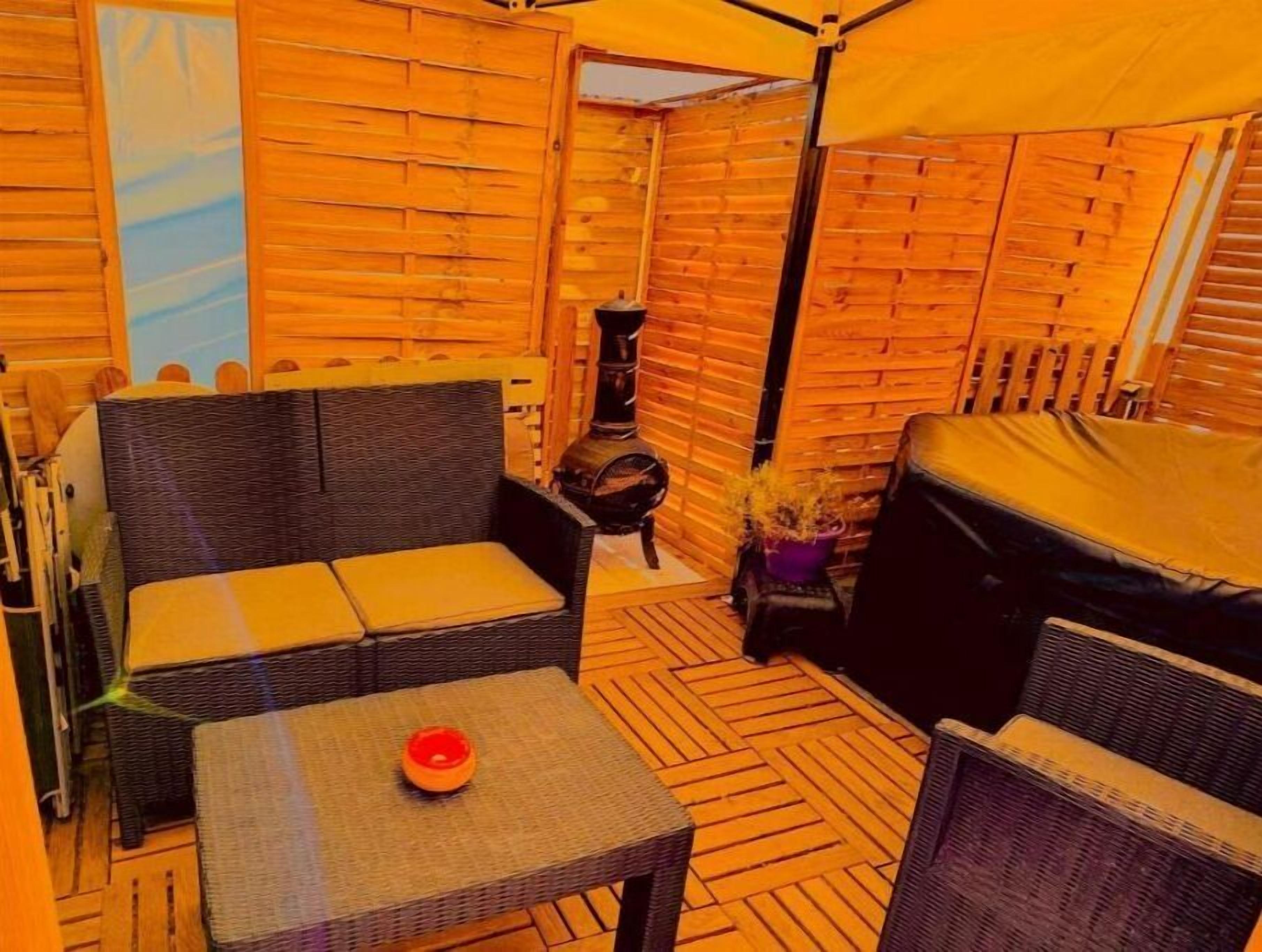 A cozy outdoor seating area with wicker furniture, a small table with a bowl, and a decorative plant.
