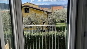 A balcony with a view of a yellow building, a metal fence, and a tiled floor. - The Sisters' house (Santo Stefano di Magra)
