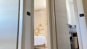 A hotel corridor with open doors leading to a bedroom and a bathroom. - The Sisters' house (Santo Stefano di Magra)
