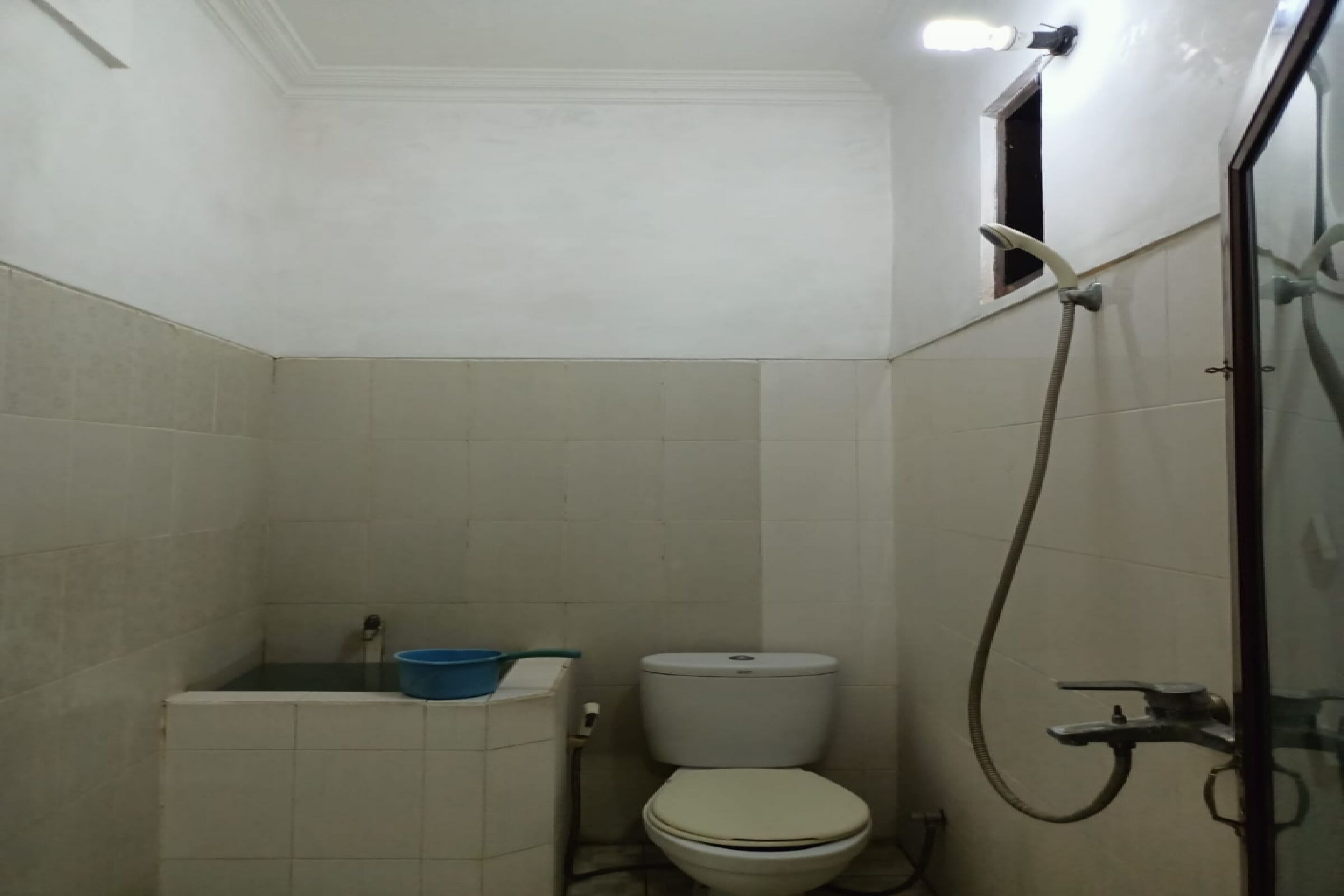 A small bathroom with a toilet, a shower, and a sink.