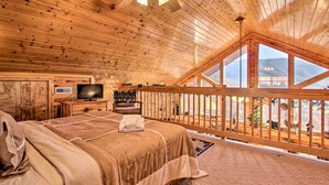 Una camera accogliente con un letto grande, una televisione e un balcone vista montagna.