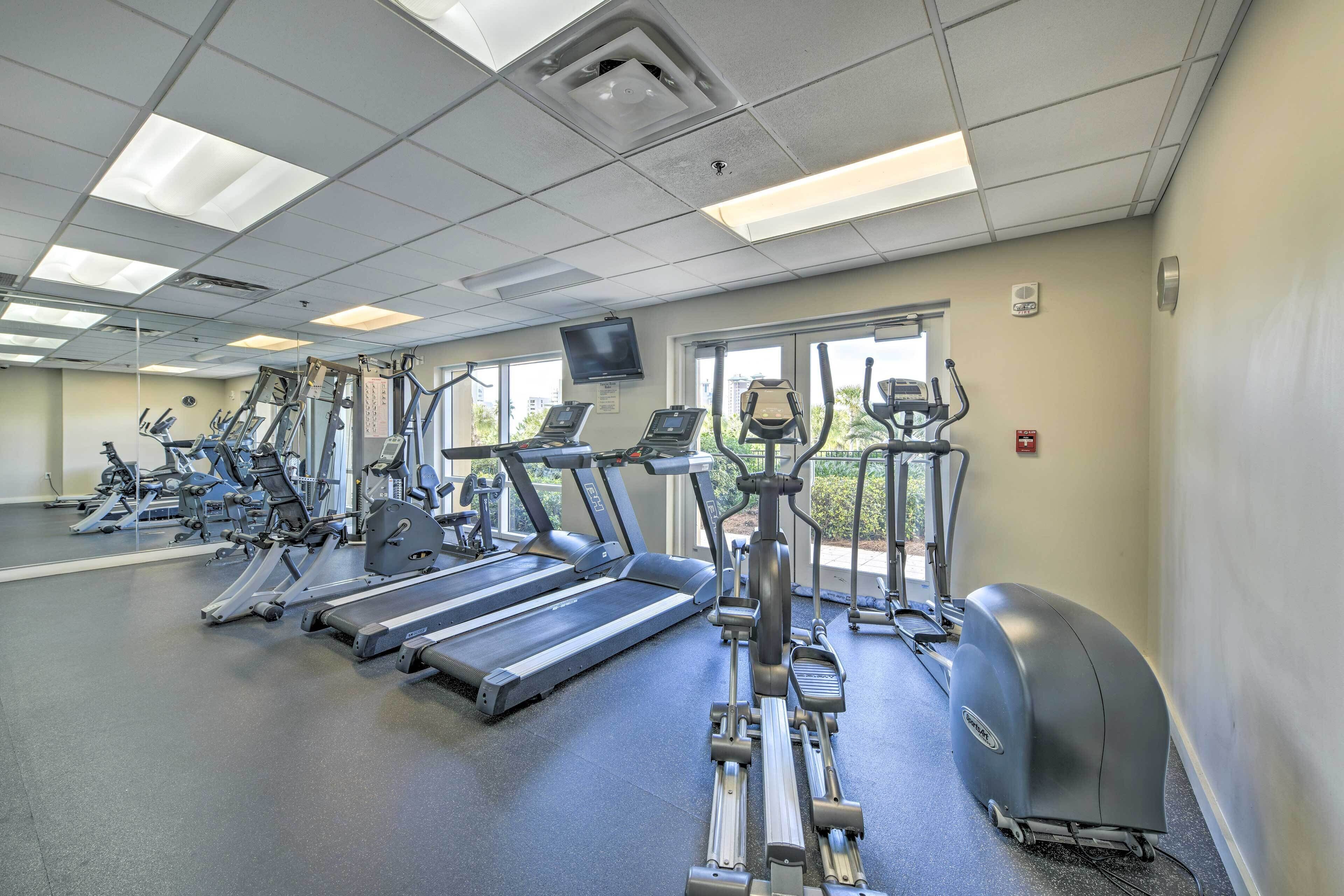 A gym with treadmills, elliptical machines, and stationary bikes.