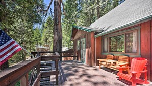 A wooden deck with outdoor seating and a view of a forest. - Comfortable Mi-wuk Village Cabin: Hike & Ski! (Mi-Wuk Village)