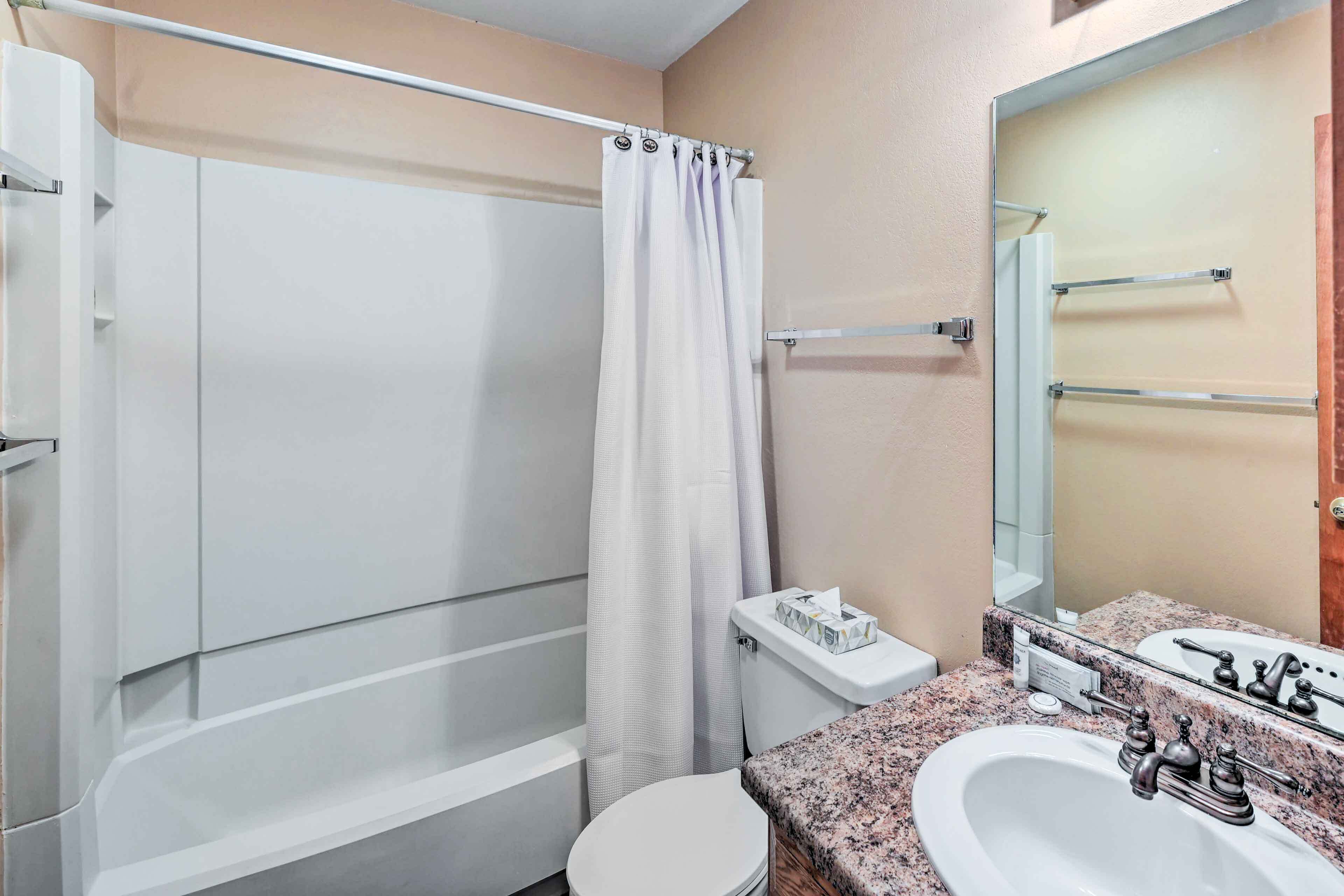 A bathroom with a shower, toilet, and sink.