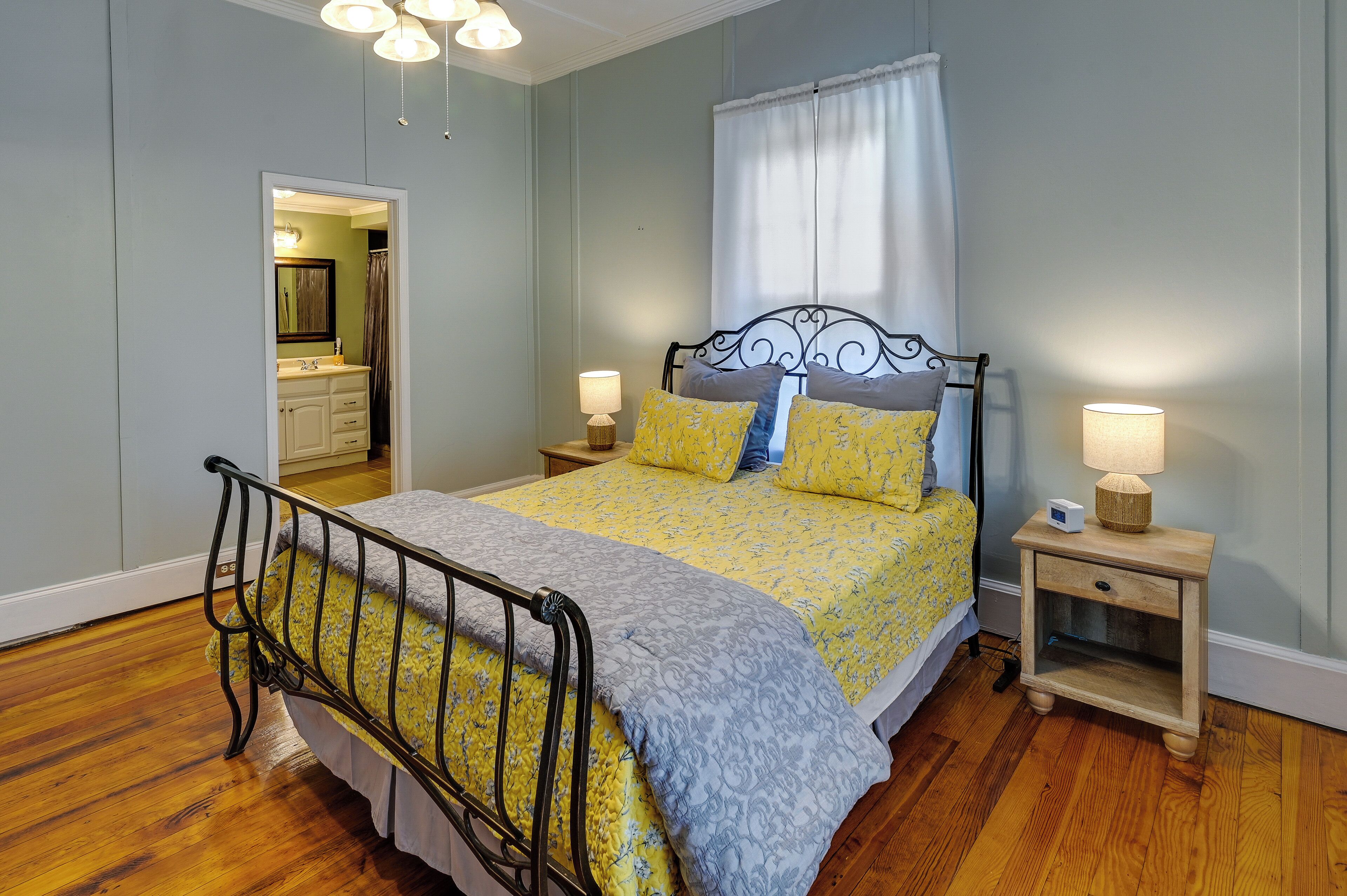 A bedroom with a bed, bedside tables, and a mirror.