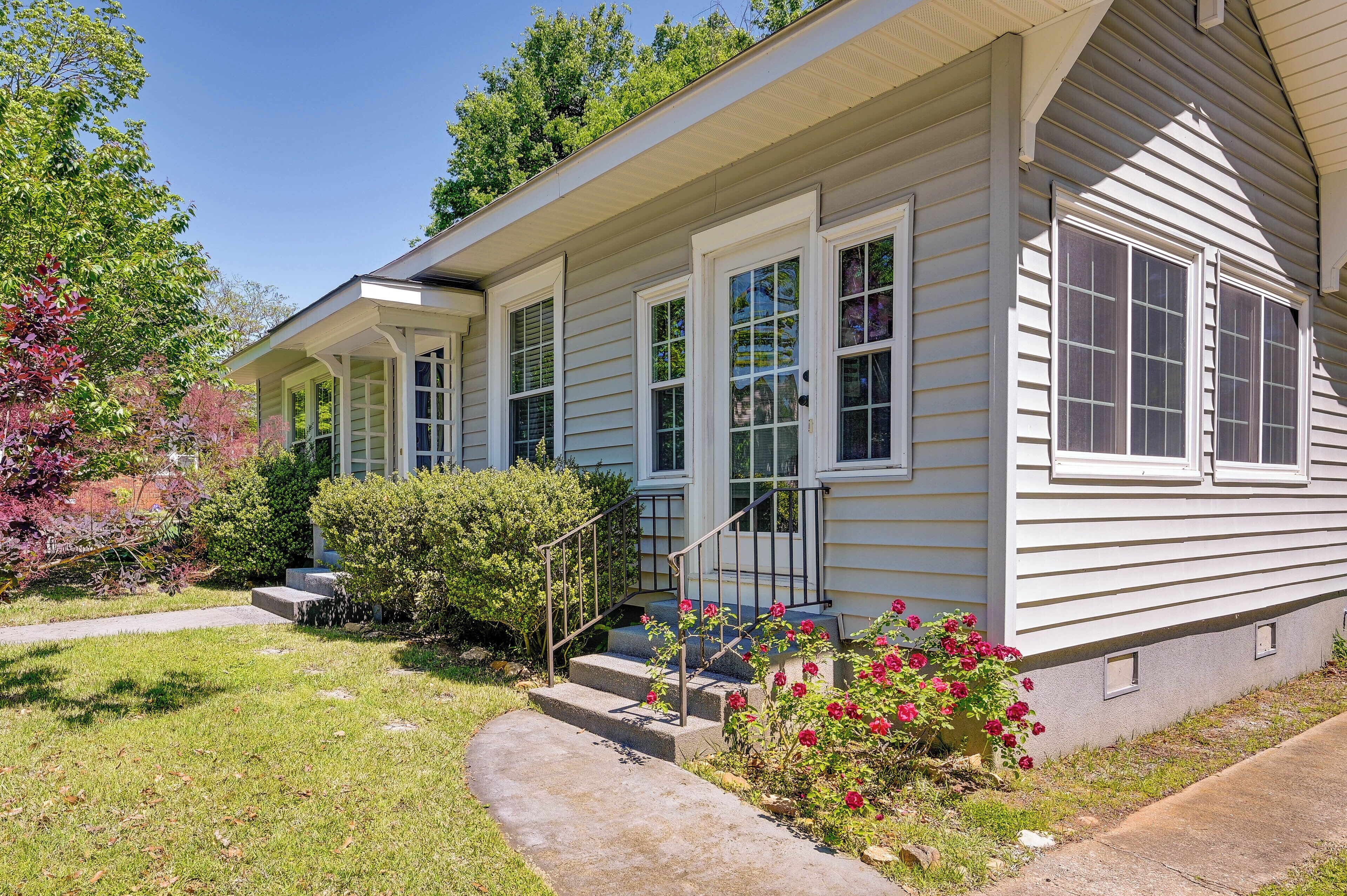 A single-story house with a front porch, a small front yard, and a pathway leading to the entrance.