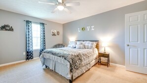 A bedroom with a bed, a nightstand, a ceiling fan, a door, and a wall with the word "LOVE". - 2 Mi to Douglas Lake, Boat Ramp: White Pine Home! (White Pine)
