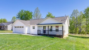 A row of single-story houses with attached garages, a grassy front yard, and a clear blue sky. - 2 Mi to Douglas Lake, Boat Ramp: White Pine Home! (White Pine)