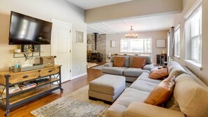 A living room with a large flat-screen TV, a wooden coffee table, a sofa, and a fireplace. - 6 Mi to Lake Tahoe: Home w/ Hot Tub & Views! (South Lake Tahoe)
