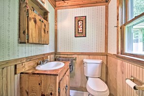A wooden bathroom with a sink, toilet, and a framed picture on the wall. - Rustic Bradford Cottage - 14 Miles to Sunapee Mtn! (Bradford)