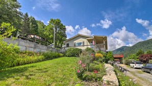 A house with a balcony, surrounded by a garden with various plants and flowers. - 'smoky Mountain Solace' Home in Maggie Valley (Maggie Valley)
