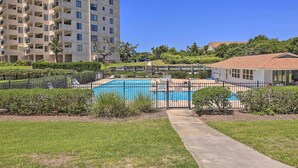 A multi-story residential building with a swimming pool surrounded by a fence. - Emerald Isle Condo w/ Direct Access to Ocean! (Emerald Isle)