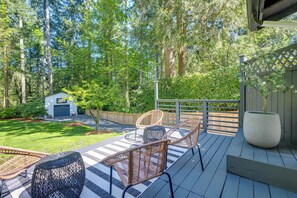 A deck with wicker chairs and a large planter. - Modern Home: 3 Miles to Woodinville Wine Country! (Woodinville)