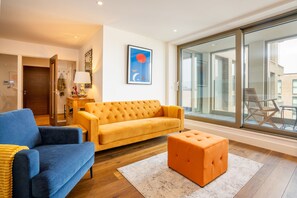 Relax in this stylish living room with a city view, featuring a sofa, ottoman, and coffee table.