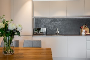 Enjoy a contemporary kitchen with a microwave, stainless steel sink, and wooden dining table.