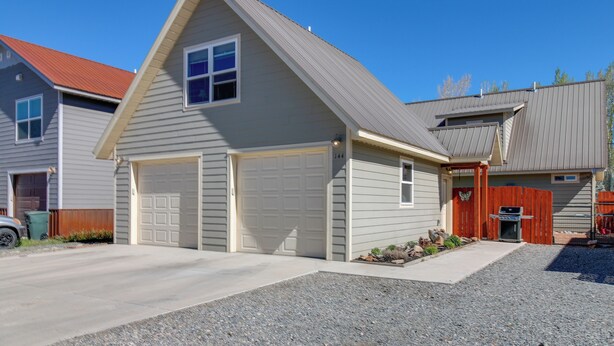 A residential house with a garage, a driveway, and a small garden area. - Gunnison Studio w/ Shuttle: 30 Mi to Crested Butte (Gunnison)