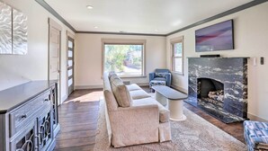 Una sala de estar moderna con chimenea, un sofá, una mesa de centro y un televisor.