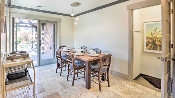 Comedor con una mesa de madera dispuesta para cuatro personas, rodeada de sillas con asientos acolchados.