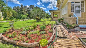 Un jardin bien entretenu, agrémenté de diverses plantes et doté d’une terrasse en bois.