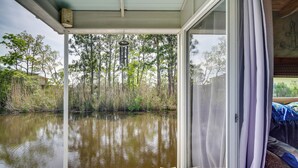 A covered deck with a view of a water body and trees. - Bay St Louis Houseboat 6 Mi to Old Town & Beach! (Bay St Louis)