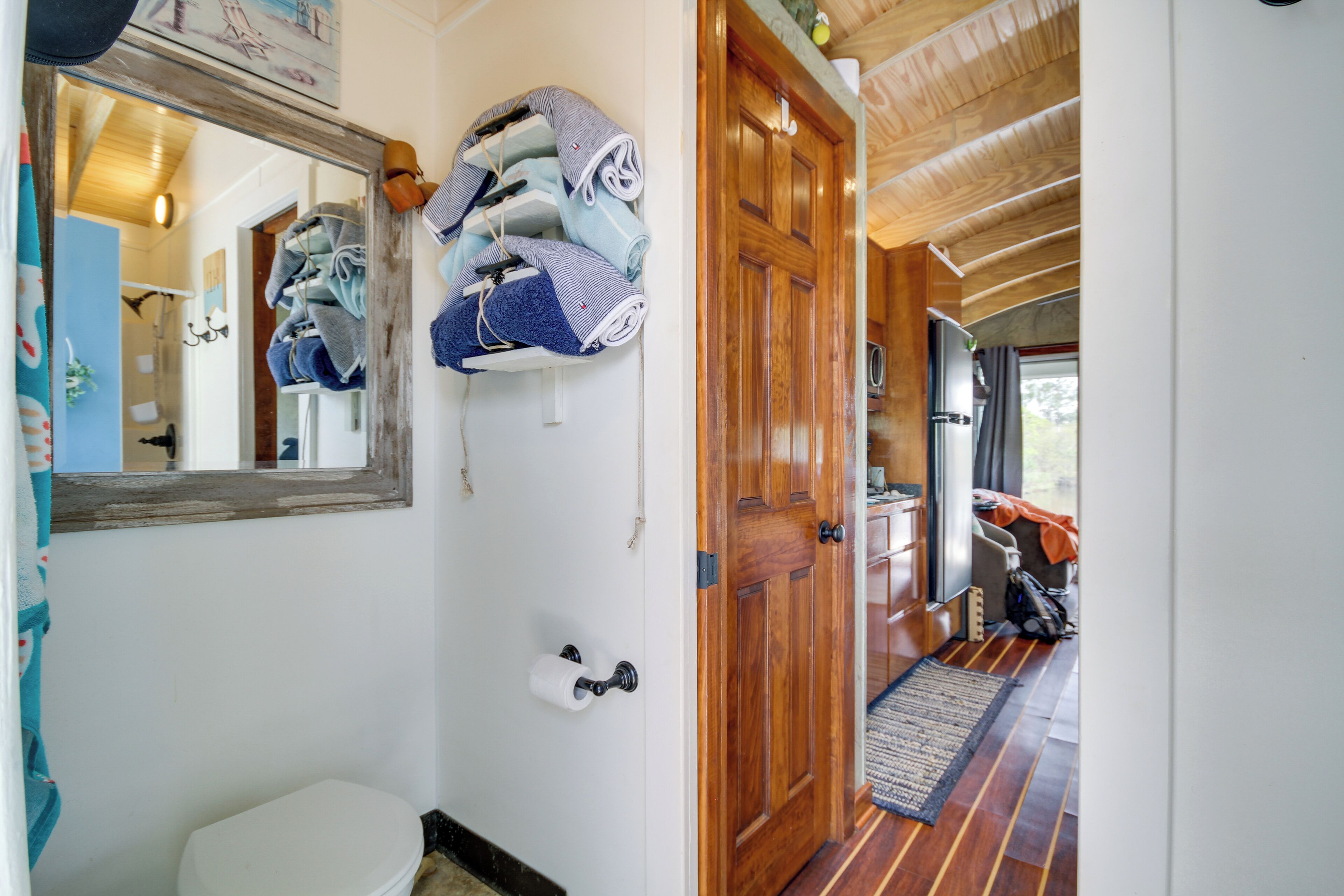 Une salle de bain avec des toilettes, un miroir et des serviettes suspendues à un porte-serviettes.