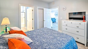 A bedroom with a bed, a dresser, a television, and a door leading to another room. - Screened Porch + Golf On-site: Myrtle Beach Condo (Myrtle Beach)