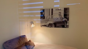 Ein Schlafzimmer mit einem Bett, einer Lampe und einem Bild an der Wand.