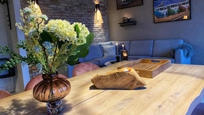 Ein Holztisch mit Blumen in einer Vase, einer Kerze und einem Holztablett.