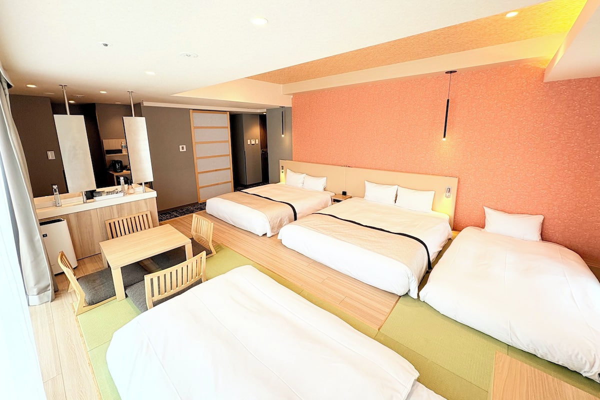 A hotel room with two beds, a desk, and a chair.