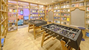 A room with two foosball tables, wooden bookshelves filled with books, and a computer monitor. - Tosei Hotel COCONE Tsukiji Ginza Premier (Tokyo)