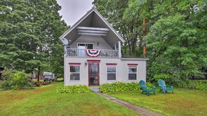 A two-story house with a front porch, a satellite dish, and a red door. - Northville Lakefront Escape w/ Deck: Walk to Lake (Northville)