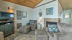 A living room with a television, a fireplace, and a couch. - Lakefront Cottage Near Wineries + State Parks! (Mears)