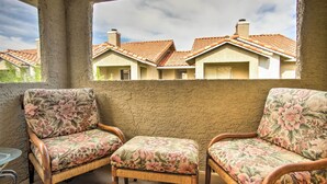 A balcony with wicker chairs and a glass table. - Convenient Las Vegas Condo: 1 Mile to the Strip! (Las Vegas)