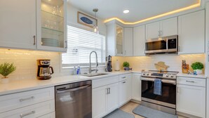 A modern kitchen with white cabinets, stainless steel appliances, and a built-in microwave. - Canal-front Haven: Pool, Dock & Lanai in Palmetto (Palmetto)